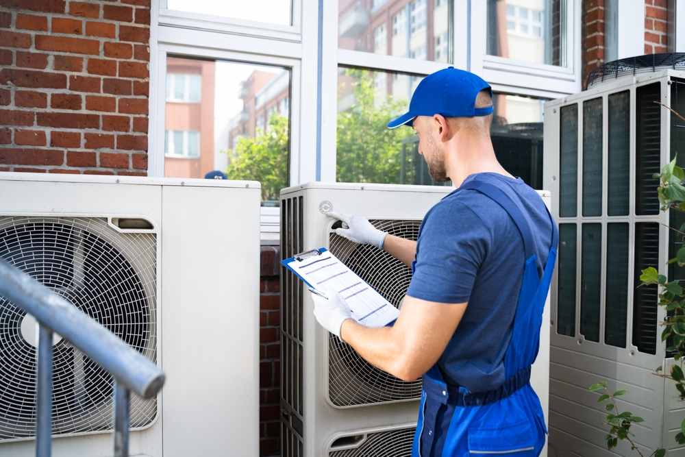 Two,Electricians,Men,Wearing,Safety,Jackets,Checking,Air,Conditioning,Unit