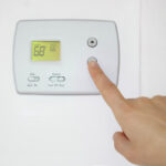 Person,Adjusting,The,Temperature,On,A,Wall,Thermostat