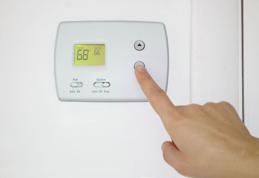 Person,Adjusting,The,Temperature,On,A,Wall,Thermostat